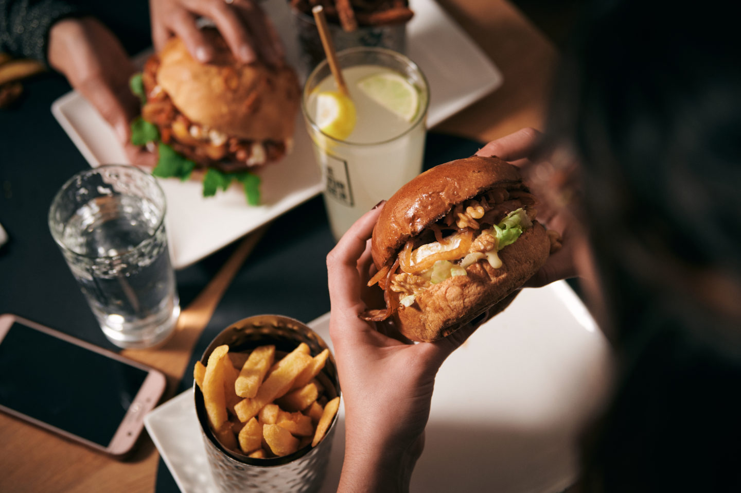 Photo de deux personnes qui mangent des burgers chez Be Burger - burger Alençon + burger Athens et limonade Be Burger